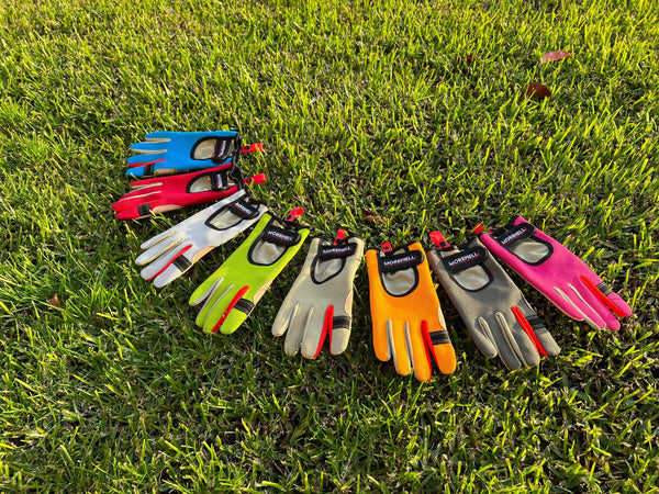 Colorful Morewell gardening gloves with artificial leather palms arranged on green grass outdoors