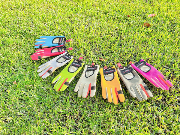 Colorful gardening gloves arranged in a row on green grass, showcasing various vibrant styles and designs.