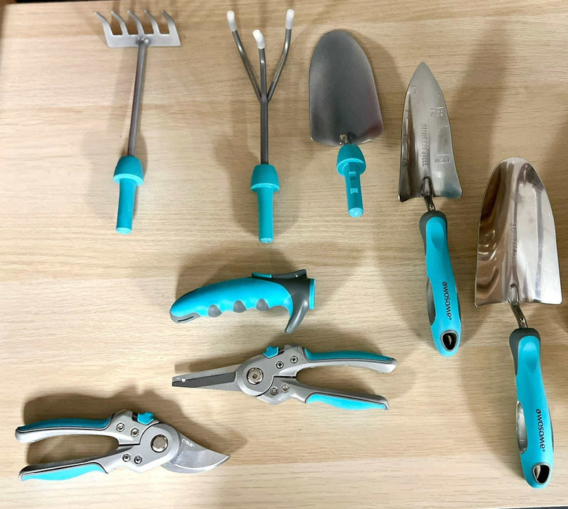 Set of blue-handled gardening tools including a rake, cultivator, hand trowels, and pruning shears on a wooden surface